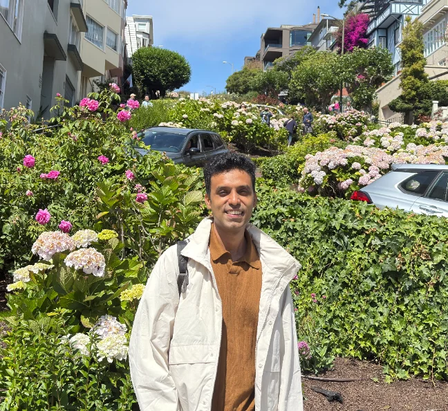 Srikrishna Iyer standing on a flower-lined street